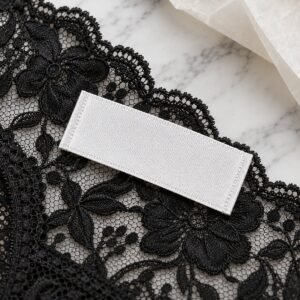 Custom woven label on black floral lace fabric macro – private label lingerie manufacturer